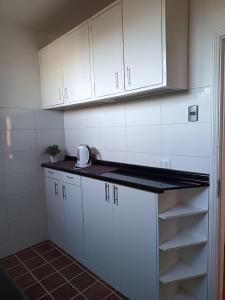 een keuken met witte kasten en een aanrechtblad bij GuestHouse in Santiago