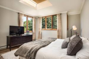 a bedroom with a white bed and a television at Meadow Ranch 384 Private Outdoor Hot Tub in Snowmass Village