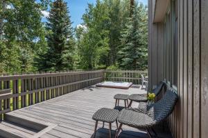 a wooden deck with two chairs and a table at Meadow Ranch 384 Private Outdoor Hot Tub in Snowmass Village