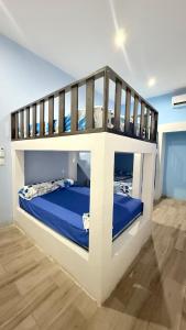 a bedroom with a bunk bed with blue sheets at Le Mirage GT in Taxisco