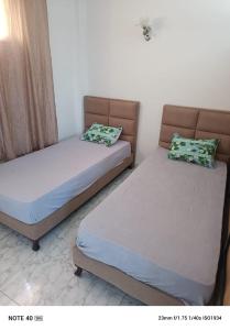 two beds sitting next to each other in a room at Résidence Tunis Carthage in Ariana