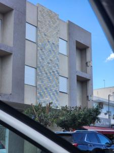 a building with a car parked in front of it at Résidence Tunis Carthage in Ariana