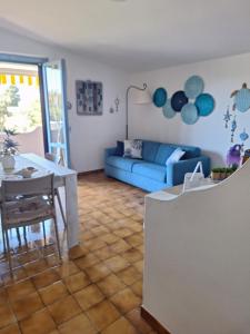 Una sala de estar con un sofá azul y una mesa. en Appartamento Oasi Azzurra, en Sellia Marina 16 fotos más
