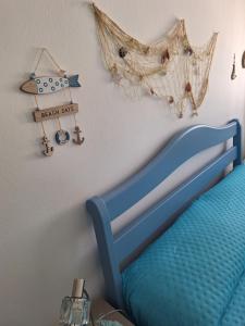 Un dormitorio con una cama azul y algunos objetos náuticos en la pared. en Appartamento Oasi Azzurra, en Sellia Marina