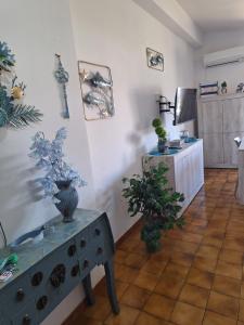 sala de estar con mesa y plantas en la pared en Appartamento Oasi Azzurra, en Sellia Marina