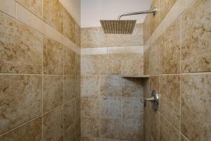 een betegelde douche met een mandje aan de muur bij Hideaway in the Heart of Downtown Moab in Moab