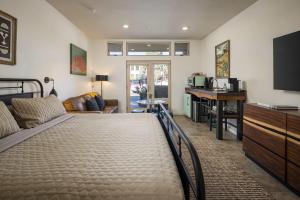 een slaapkamer met een bed, een bureau en een televisie bij Hideaway in the Heart of Downtown Moab in Moab +7 foto's