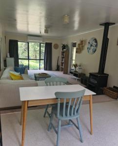 a living room with a couch and a table and chairs at Peaceful Rural Cottage in Kopuaranga