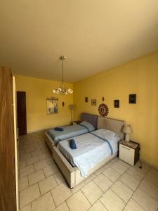 a bedroom with a large bed and yellow walls at Fgura Spacious Apartments in Tal-Liedna +2 photos