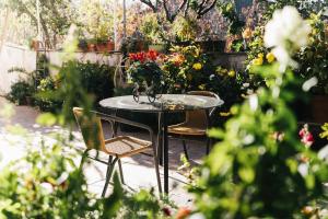 une table et des chaises dans un jardin fleuri dans l'établissement Kyperounta Retreat, à Kyperoúnta