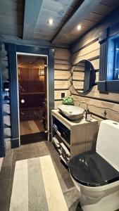 a bathroom with a toilet and a mirror at Cozy Log Cabin With A View Over Hedmarken in Løten