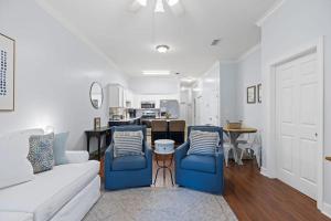 a living room with a white couch and blue chairs at Happy Days - Seagrove Highlands in Santa Rosa Beach