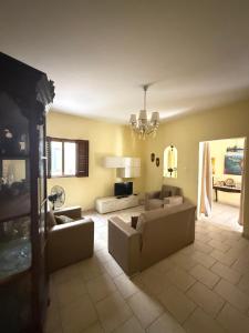 a living room with two couches and a chandelier at Fgura Spacious Apartments in Tal-Liedna