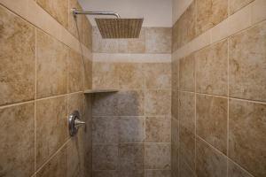 een betegelde badkamer met een douche met mand bij Downtown Hideaway in the Heart of Moab in Moab