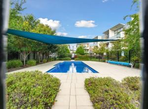 een blauwe luifel boven een zwembad in een tuin bij Tranquil 1-Bed Apartment with Courtyard, Pool, BBQ in Phillip