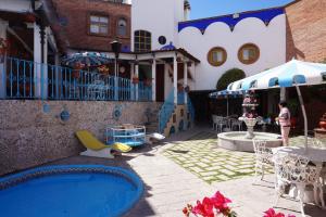 a backyard with a pool and a table and chairs at Suites Poza Real in Tequisquiapan