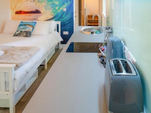 ein kleines Zimmer mit einem Bett und einem Waschbecken in der Unterkunft Woodpecker - Uk43451 in Hayle