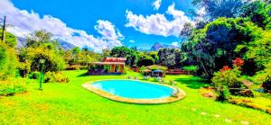 a large yard with a swimming pool in the grass at Pousada dos Chalés - Araras in Araras Petropolis