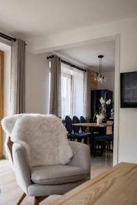 a living room with a chair and a dining room at Bella Monte in Szczyrk
