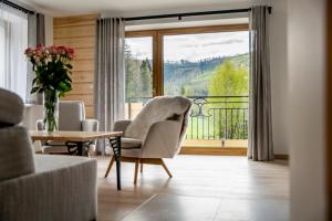 a living room with a chair and a table and a window at Bella Monte in Szczyrk