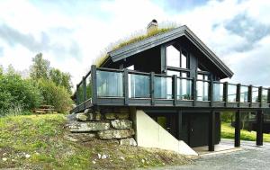 a house on top of a hill with glass at New modern cabin in Beitostølen in Beitostøl