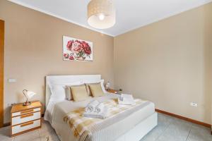 a bedroom with a white bed and a night stand at Petalo Bianco 100m from lake - Happy Rentals in Baveno