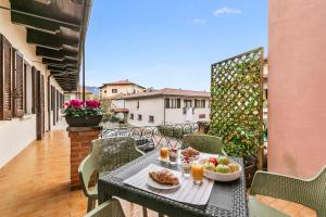a table with a bowl of fruit on a balcony at Petalo Bianco 100m from lake - Happy Rentals in Baveno
