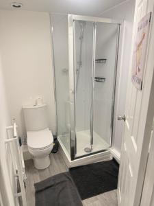 a bathroom with a toilet and a glass shower at Saunders house in Gillingham