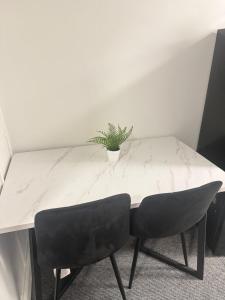 a white table with a potted plant on top of it at Saunders house in Gillingham