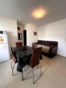 a dining room with a table and chairs and a couch at depto a 1 cuadra de peatonal, luminoso con pile y cochera in Villa Carlos Paz