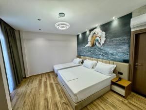 a bedroom with two beds and a painting on the wall at Comfort by Rezidence In Hotel in Tirana