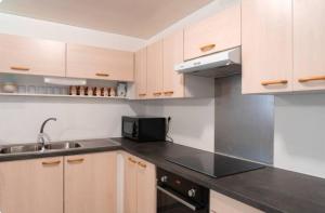 a kitchen with wooden cabinets and a black counter top at Studio Teava in Papeete