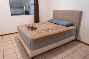 a large bed in a room with a window at Studio Teava in Papeete