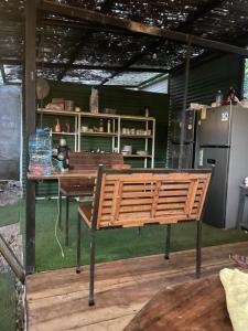 a patio with a table and a bench and a refrigerator at Maudie in Santa Teresa Beach