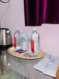 two bottles of water on a plate on a table at Hotel Siddhartha in Bodh Gaya