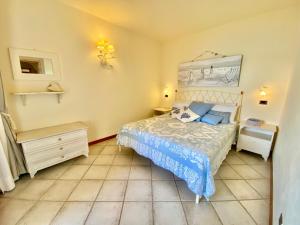 a bedroom with a bed and a dresser and a bed sidx sidx sidx sidx at Luxury apartment Ginestra sea view with common swimming pool just 50 mt from the beach in Golfo Aranci +25 photos