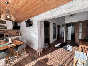 a kitchen and dining room with a wooden ceiling at Cazare La Luiza b in Şura Mare