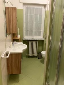 a bathroom with a sink and a toilet and a window at Casa Cuore Mother Ross in Ariano Irpino