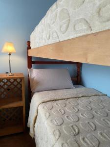 Un dormitorio con una litera con una lámpara sobre una mesa. en Cabana Mirador Sumajpacha, en Tilcara