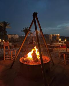 a fire pit on the beach at night at Afraklie Camp in Merzouga