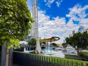 Una vista del Burj Khalifa desde un parque con una valla. en Luxury Grande 48 with Burj Khalifa & Fountain Views, en Dubái