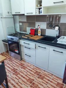 a kitchen with white cabinets and a stove top oven at Promenada Mall Apartment4you in Craiova
