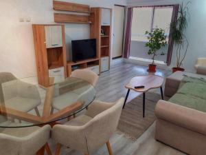 a living room with a glass table and chairs at Promenada Mall Apartment4you in Craiova