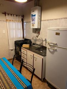 cocina pequeña con nevera y fogones en Cabana Mirador Sumajpacha, en Tilcara