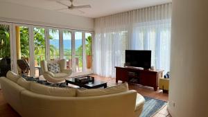 ein Wohnzimmer mit Couch und Flachbildfernseher in der Unterkunft No 3 @ The Hill Apartments in Port Douglas