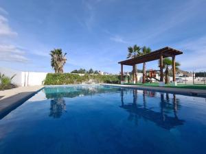 a swimming pool with a gazebo and blue water at SHINYADO Casa de Huéspedes Cabo San Lucas in Cabo San Lucas