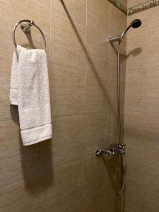 Una ducha con una toalla blanca colgada en la pared. en Cabana Mirador Sumajpacha, en Tilcara