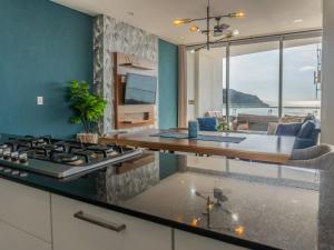 a kitchen with a stove and a living room at De lujo a pie de playa con vista directa al mar in Isla Venados