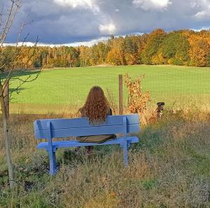 een vrouw op een blauwe bank in een veld bij SoBądź - Po prostu bądź in Sobącz