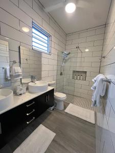 ein Badezimmer mit zwei Waschbecken, einer Toilette und einer Dusche in der Unterkunft 4min walk to corcega beach,spacious 2bedroom 2bath in Rincon + 23 Fotos